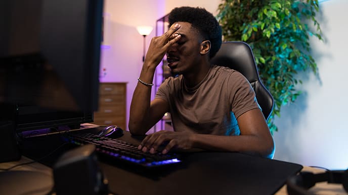 Um gamer, no computador, desapontado com a performance do seu PC no jogo.
