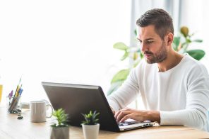 Um homem usando o notebook e conectado a internet banda larga da Desktop.