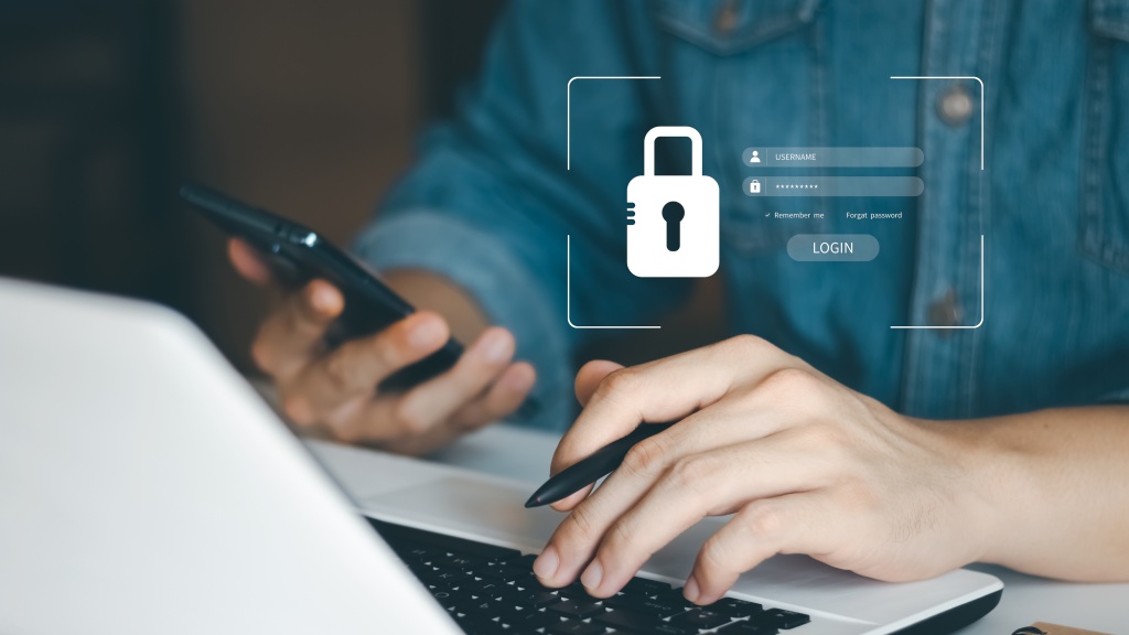 Pessoa mexendo no celular e computador de forma segura graças aos dados criptografados.