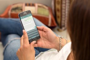 Mulher segurando celular aberto em conversa representando como formatar texto no WhatsApp