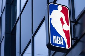 Placa fixada em parede com logo da NBA, representando o app NBA Team Pass, disponível na Desktop Internet