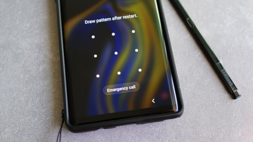 Parte de um celular Samsung com a tela de bloqueio exigindo senha, ao lado de uma caneta Smart Touch.