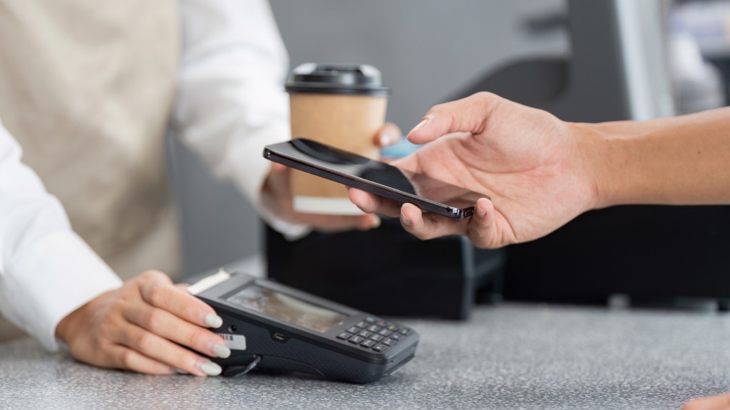 Pessoa realizando pagamento com NFC no celular aproximando o aparelho à maquininha.