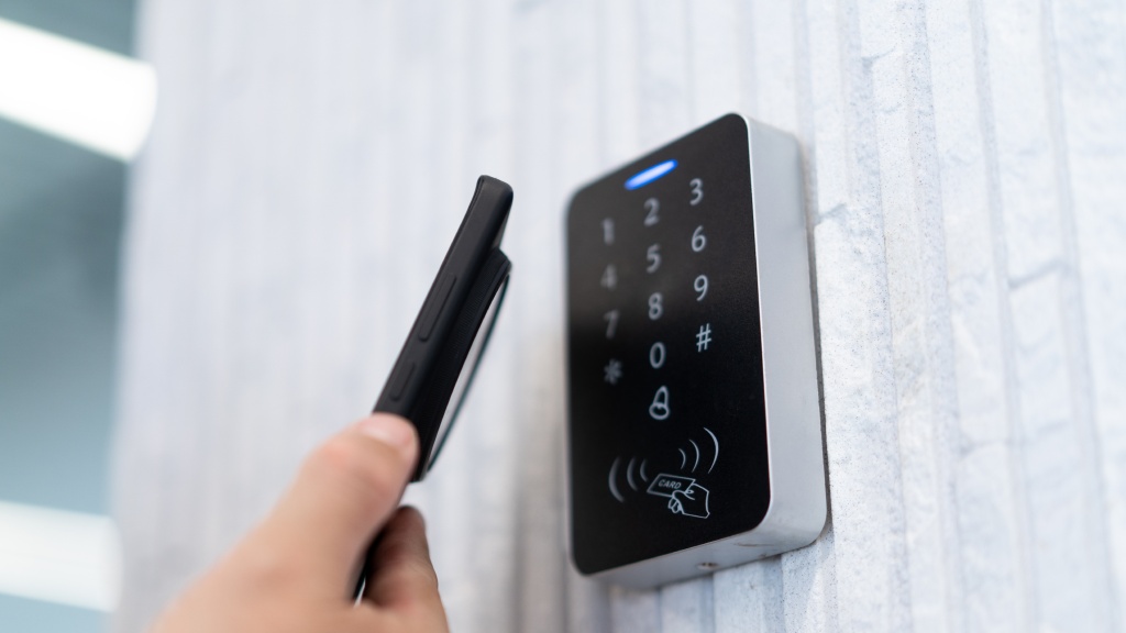 Celular aproximado de um leitor NFC em parede, mostrando o uso do NFC no celular comunicação sem contato.