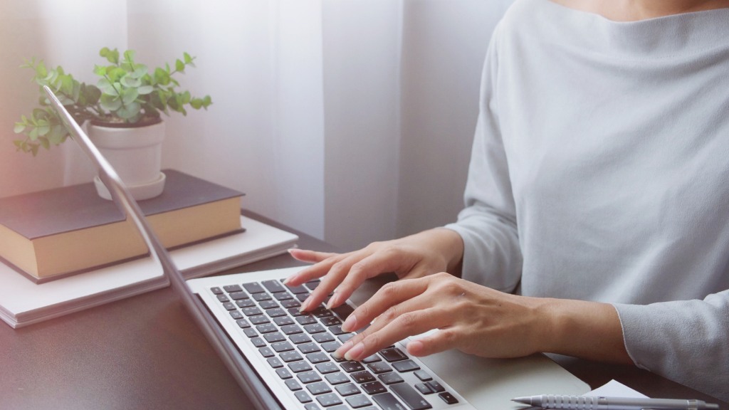 Mulher digitando no notebook enquanto entra em contato com a Desktop na Black Friday para contratar um plano de internet.
