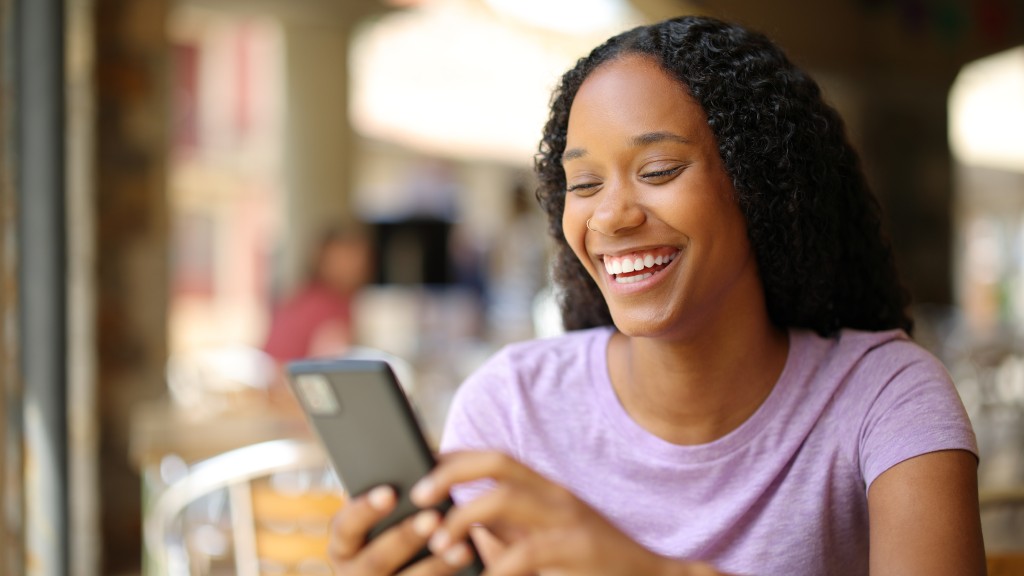 Moça sorridente com camiseta roxa clara, segurando celular conectado a uma rede hotspot.