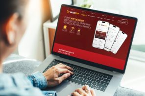 Uma pessoa segurando o notebook no colo. Na tela, a página da 