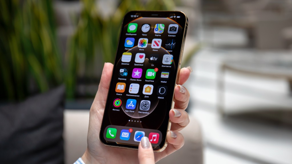 Mãos segurando celular iPhone, que exibe a Tela de Início do iPhone, representando a dúvida de como desativar aplicativos em segundo plano no aparelho.