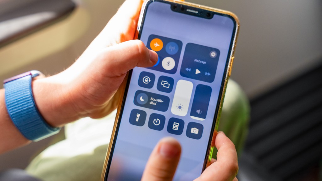 Mãos segurando um iPhone, que exibe a Central de Controle do aparelho e o ícone do modo avião ativado.