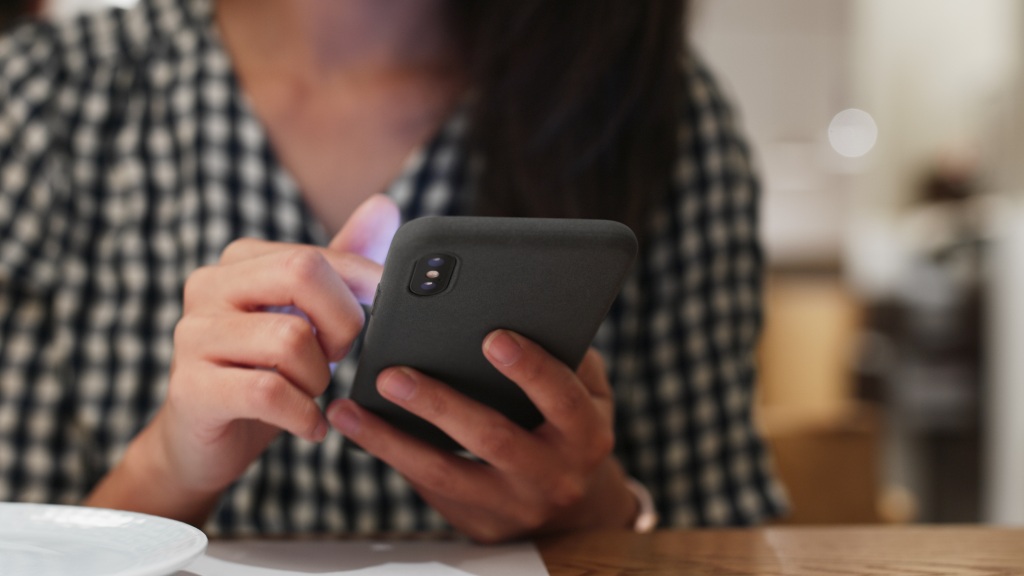 Pessoa segurando celular enquanto confere o consumo dos dados móveis no aparelho.