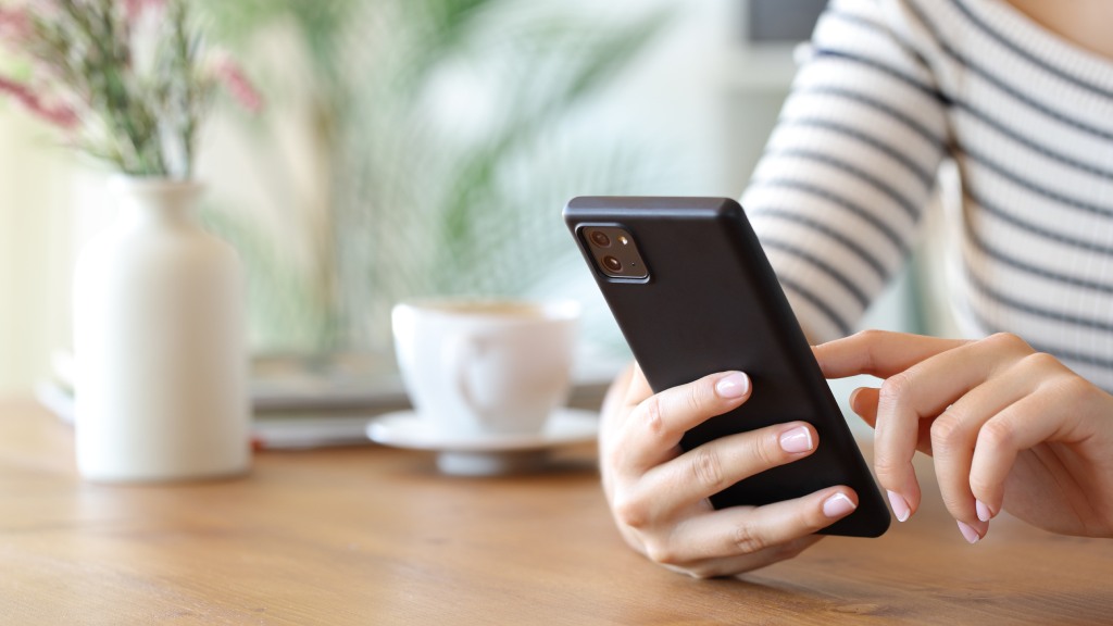 Pessoa segurando celular enquanto realiza ajustes para consumir menos memória RAM.