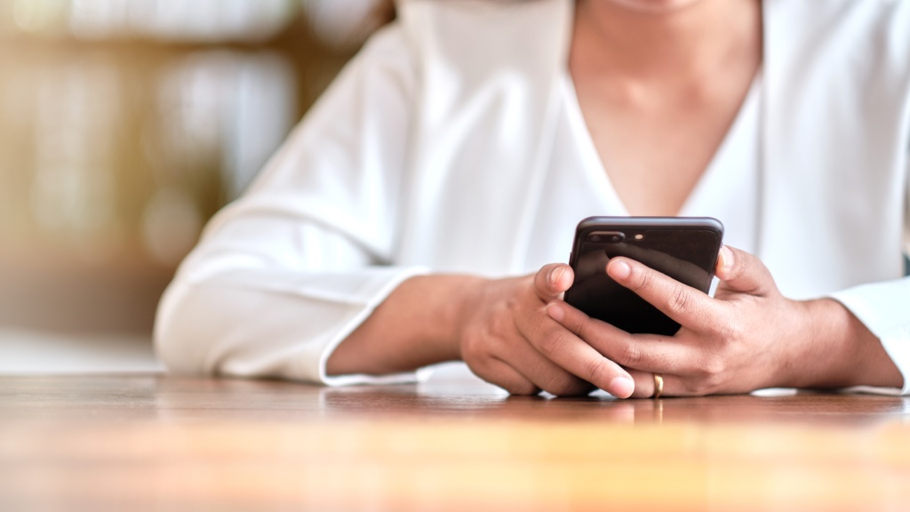 Pessoa segurando celular enquanto desativa os aplicativos em segundo plano.