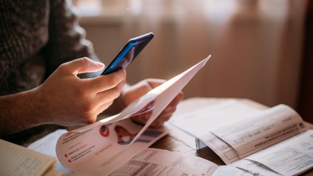 Pessoa apontando a câmera do celular para o código de Pix de um boleto, habilitando o Pix automático no app do banco do aparelho.