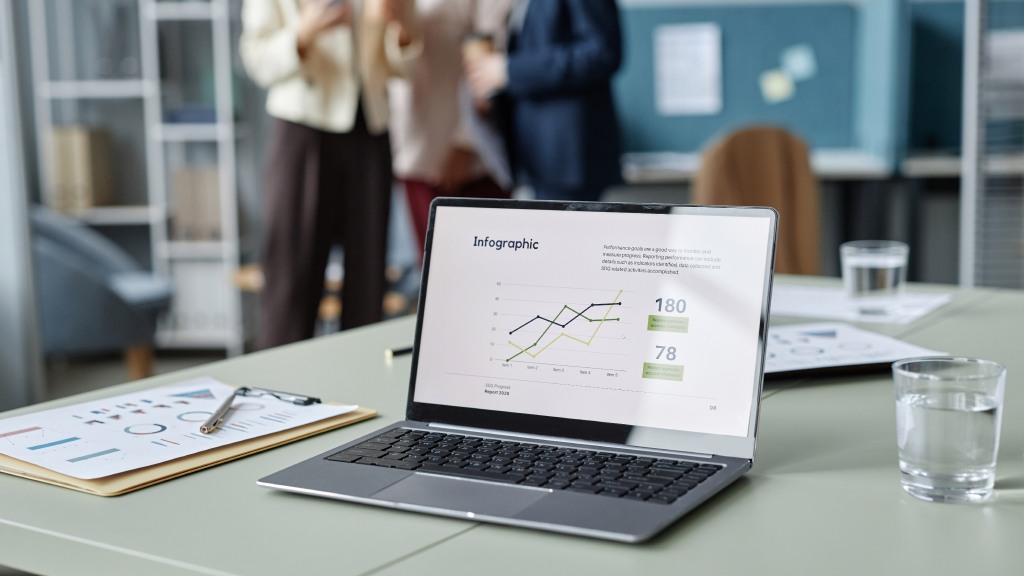 Notebook sobre a mesa de um escritório, com a tela exibindo infográfico e dados empresariais, representando o uso de internet fibra no ambiente corporativo.