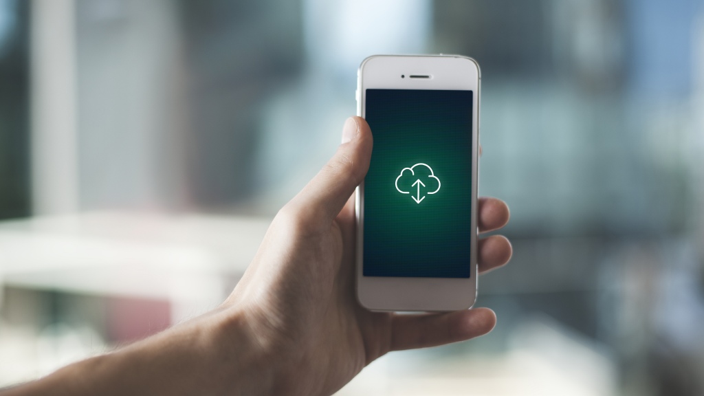 Mão segurando um celular que exibe na tela um ícone de nuvem com setas para cima e para baixo, simbolizando a ação de reiniciar o aparelho para resolver problemas nos dados móveis.