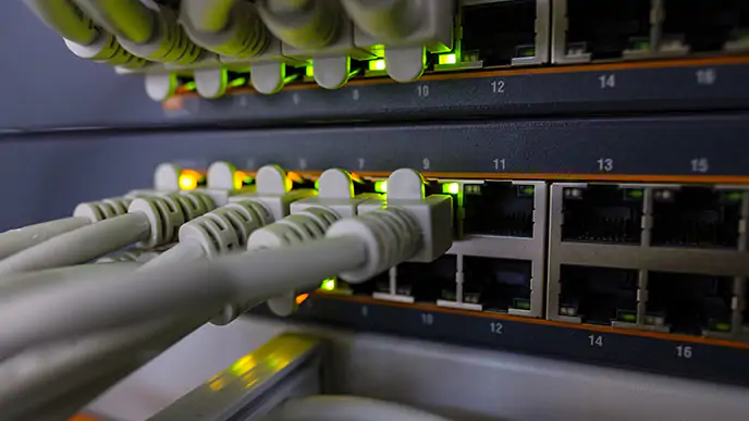 Além de ser proibido, compartilhar internet pode sobrecarregar a rede e prejudicar a sua conexão. Diversas entradas ethernet e alguns fios conectados. Dos fios conectados sai uma luz amarela.